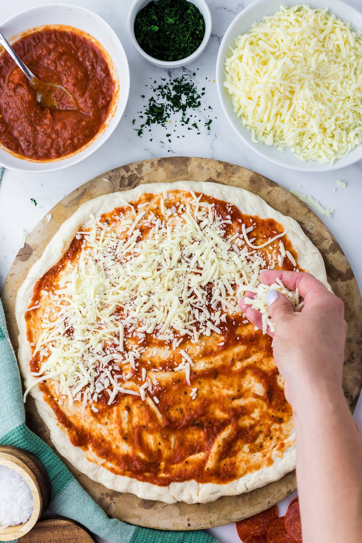 adding cheese to homemade pizza