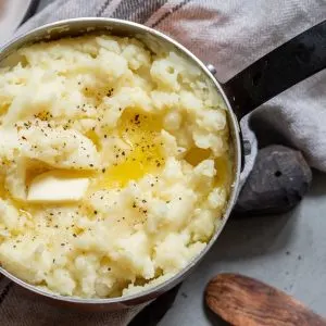 Mashed potato with spoon, in a copper pot