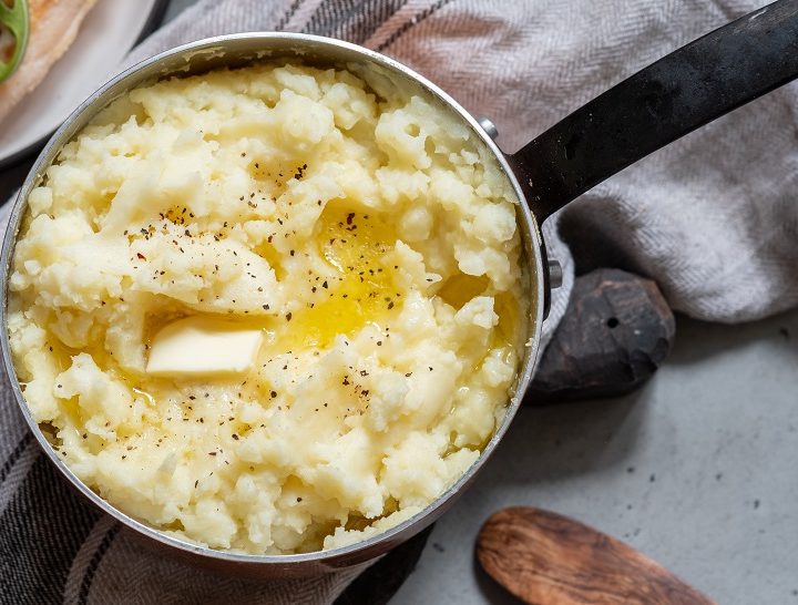 Mashed potato with spoon, in a copper pot