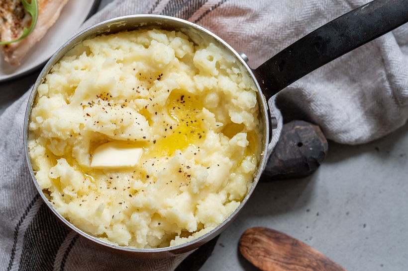 Mashed potato with spoon, in a copper pot