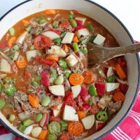 Vegetable soup with wooden spoon in dutch oven