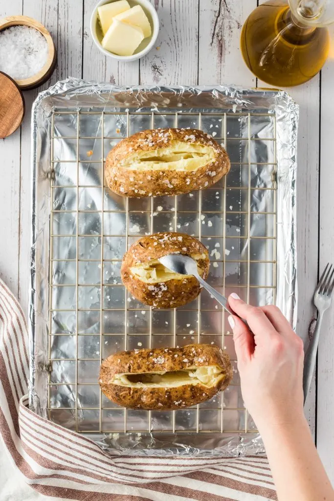 loosening the insides of potatoes with a spoon