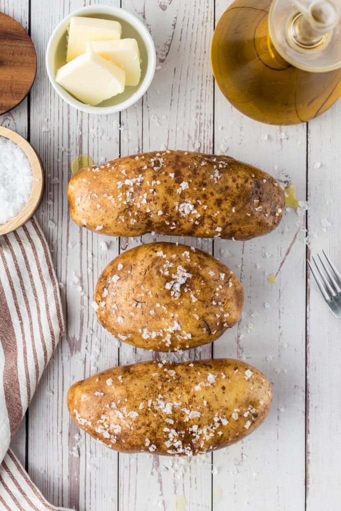 three potatoes coated in olive oil and salt