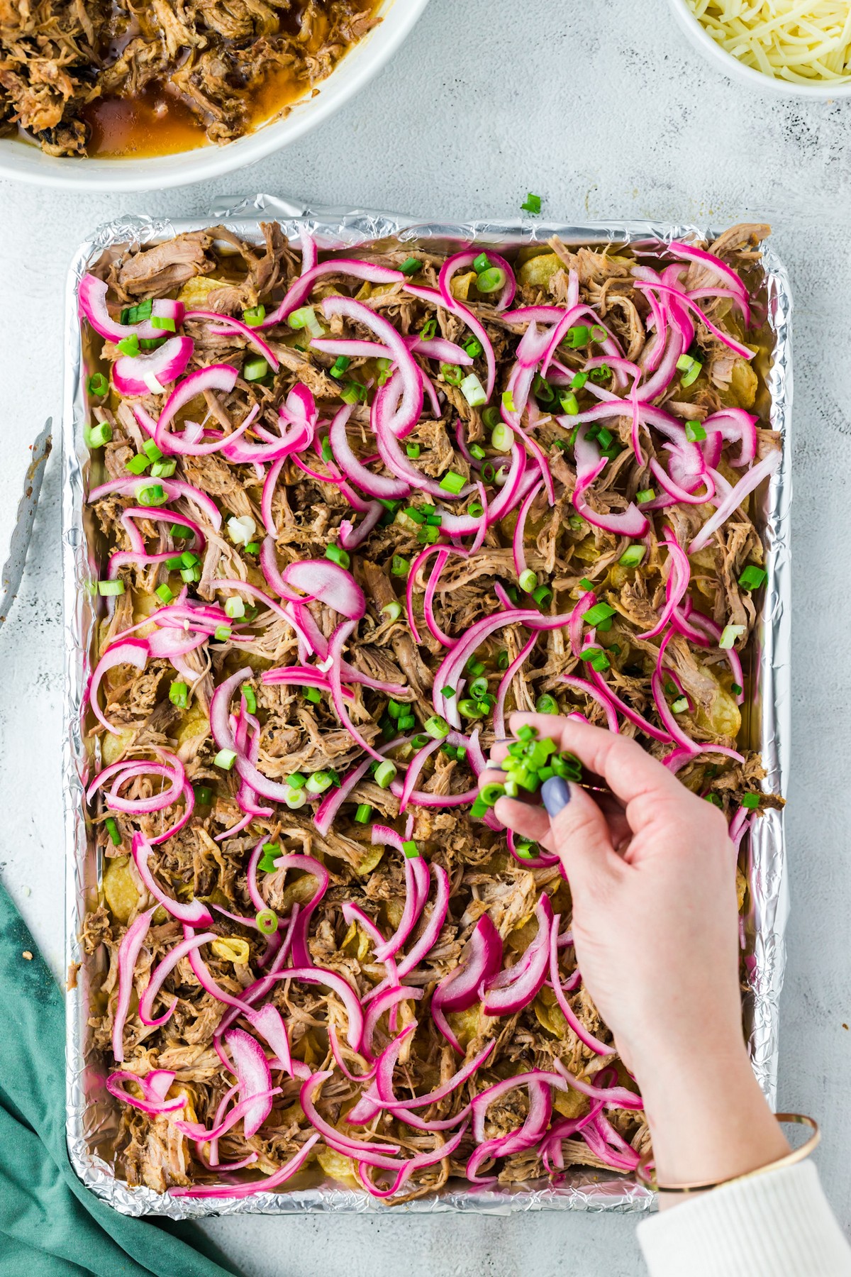 adding green onion to nacho platter