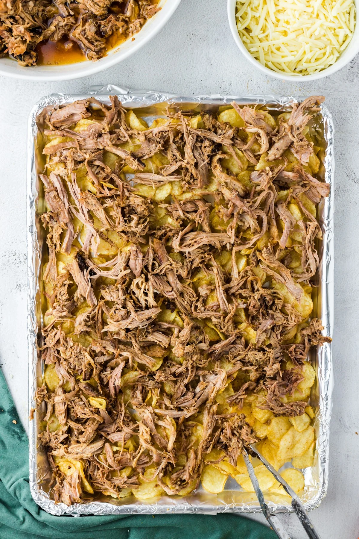 layering pulled pork on top of potato chips