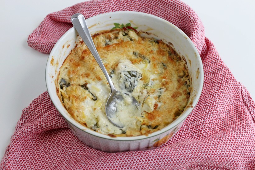 Baked Spinach and Artichoke Dip with a red towel