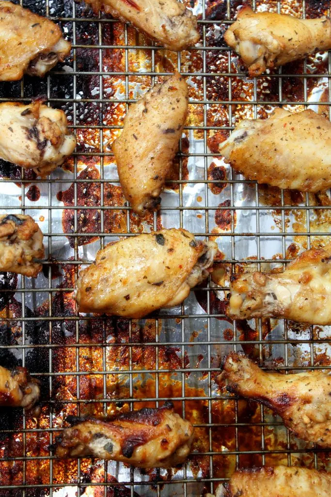 These chicken wings are tender on the inside and covered with perfectly sticky BBQ sauce on the outside. Nothing quite says gameday like these oven-baked wings! #wings #chickenwings #bakedwings #bakedchickenwings #recipe #easyrecipe #appetizers #appetizerrecipes #appetizerseasy #appetizersforparty #gamedayrecipes #gamedayfood Chicken Wings baked on cookie sheet