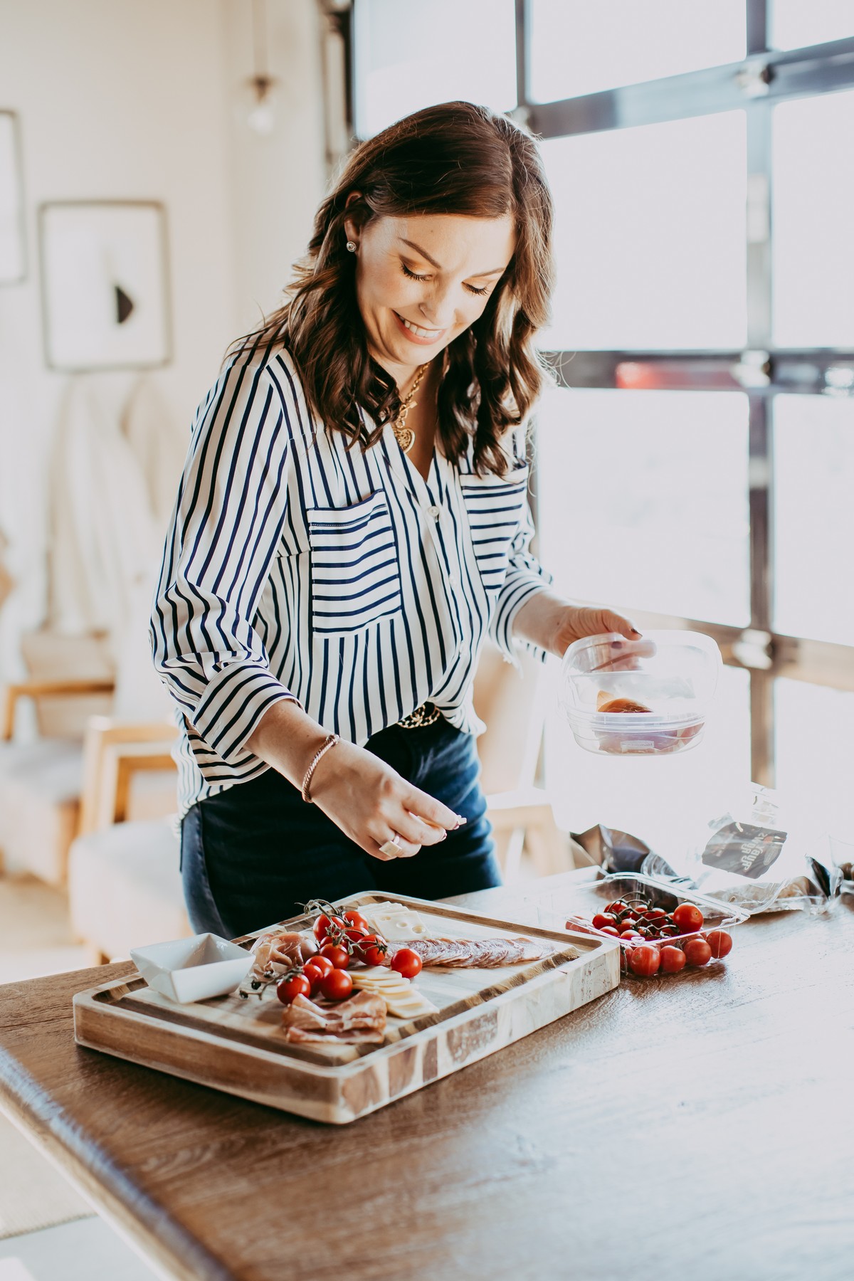 woman assembling charcuterie board