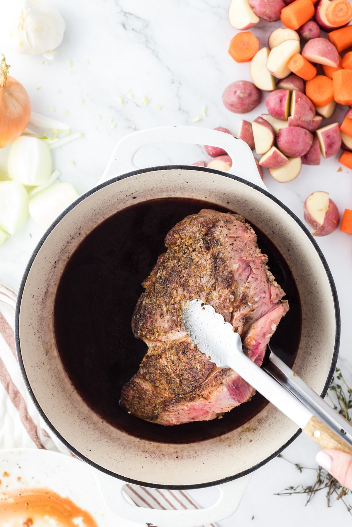 adding seared chuck roast to dutch oven