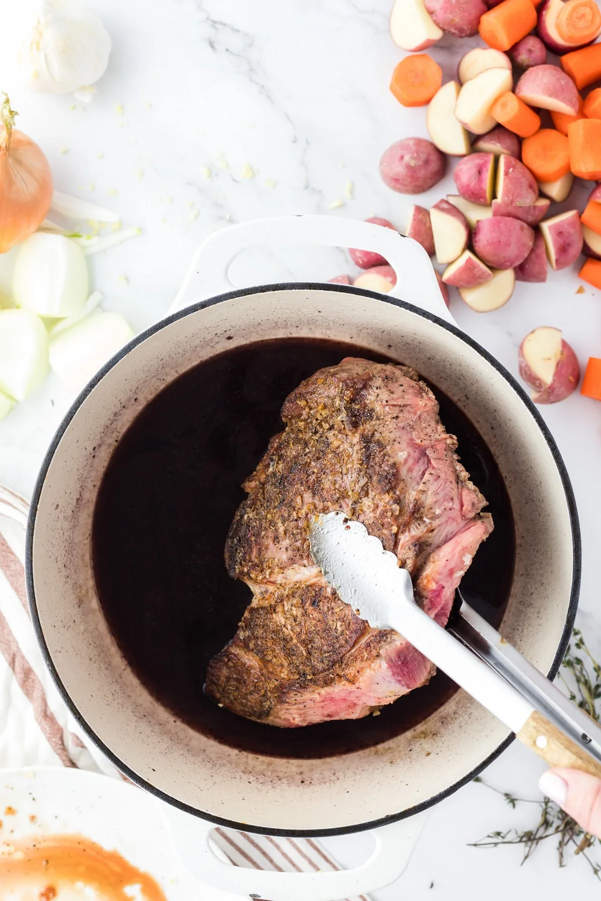 adding seared chuck roast to dutch oven