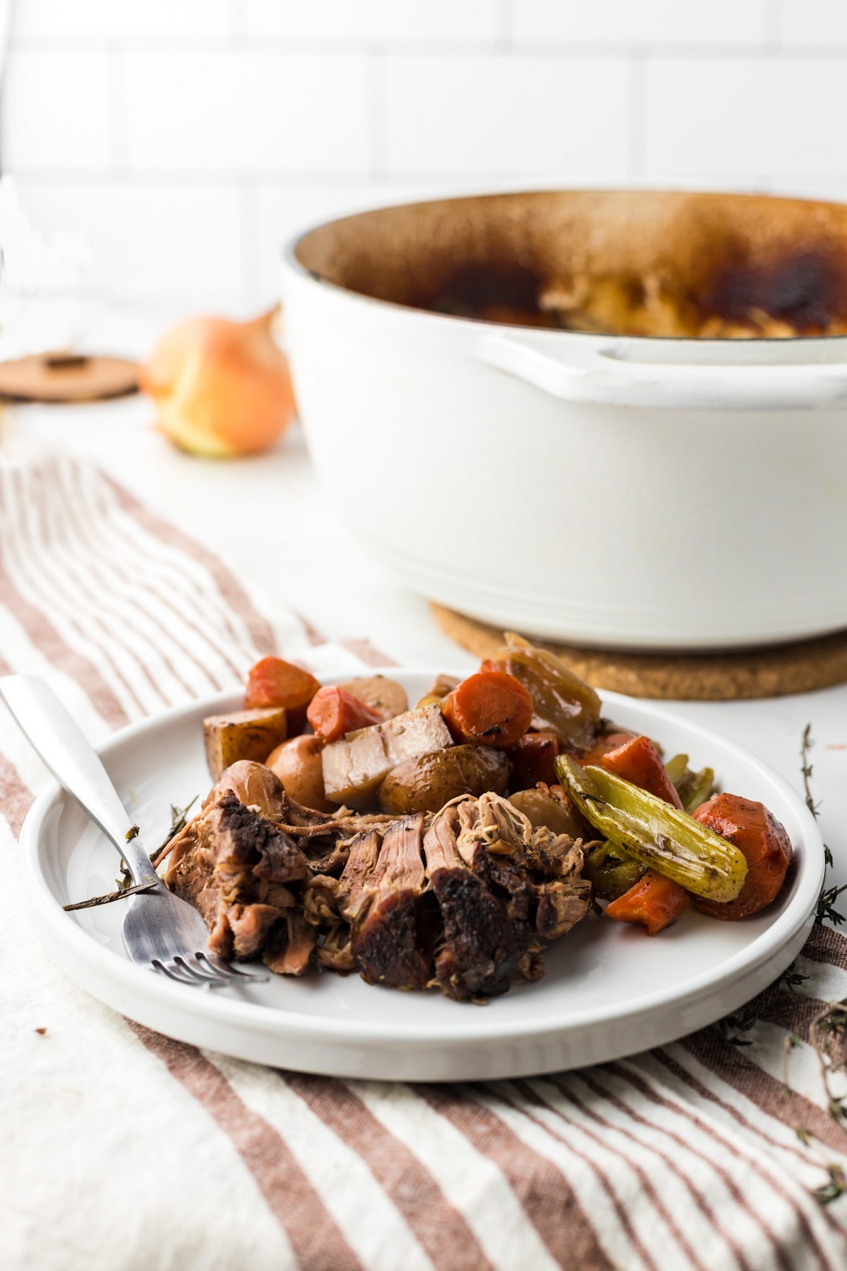 shredded pot roast with vegetables on white plate