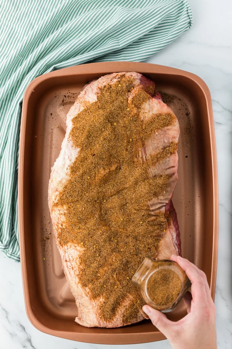 applying dry rub to brisket