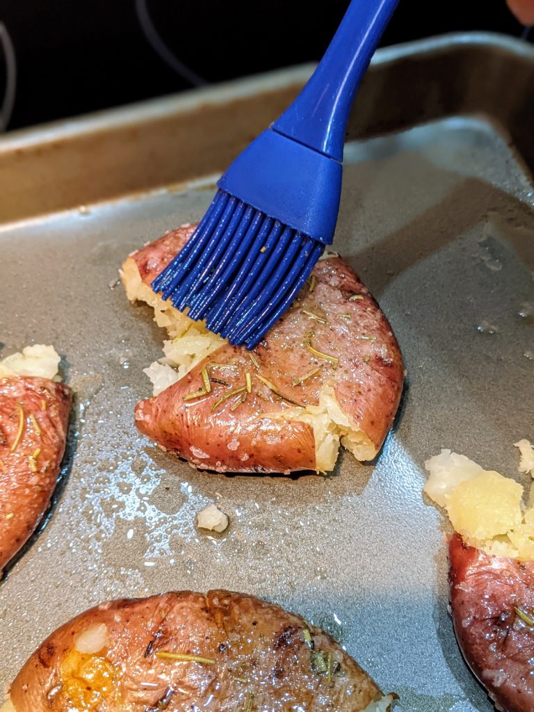 brushing seasoning on red potatoes