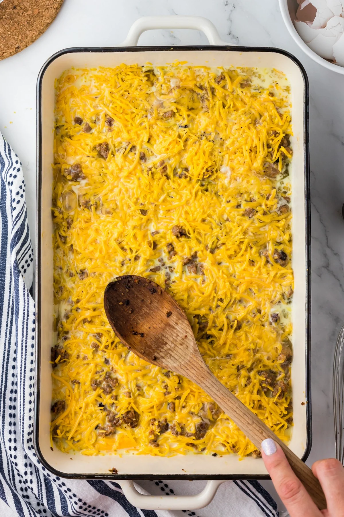 uncooked breakfast casserole and wooden spoon