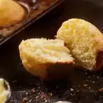 Corn muffin split in half with butter