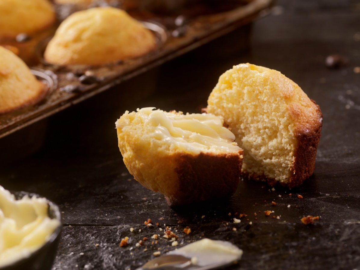 Corn muffin halved with muffins in background