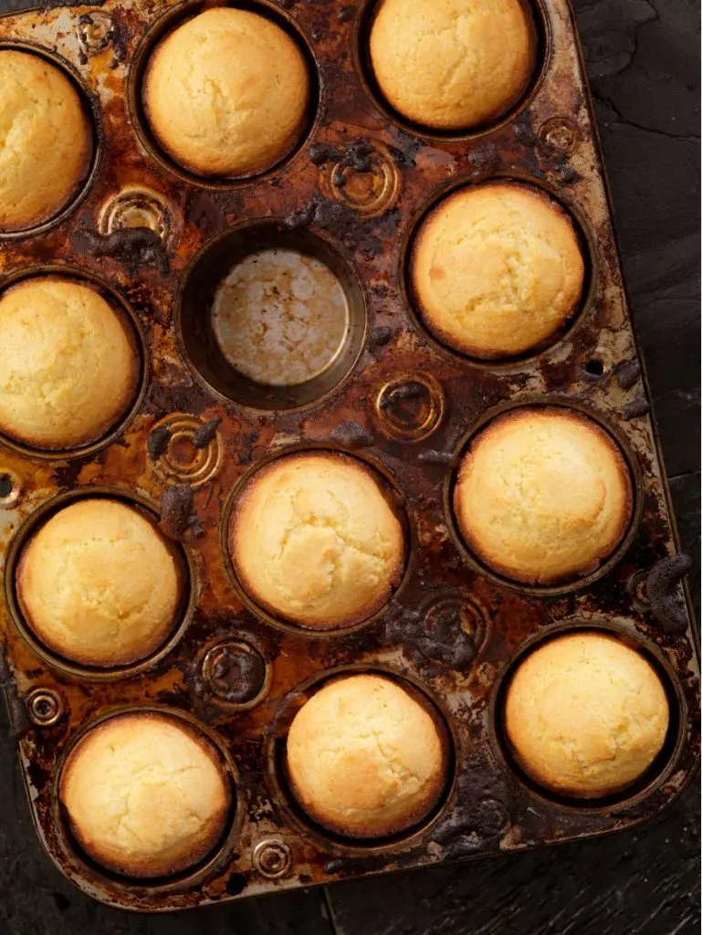 Muffin tin of corn muffins with one missing from middle