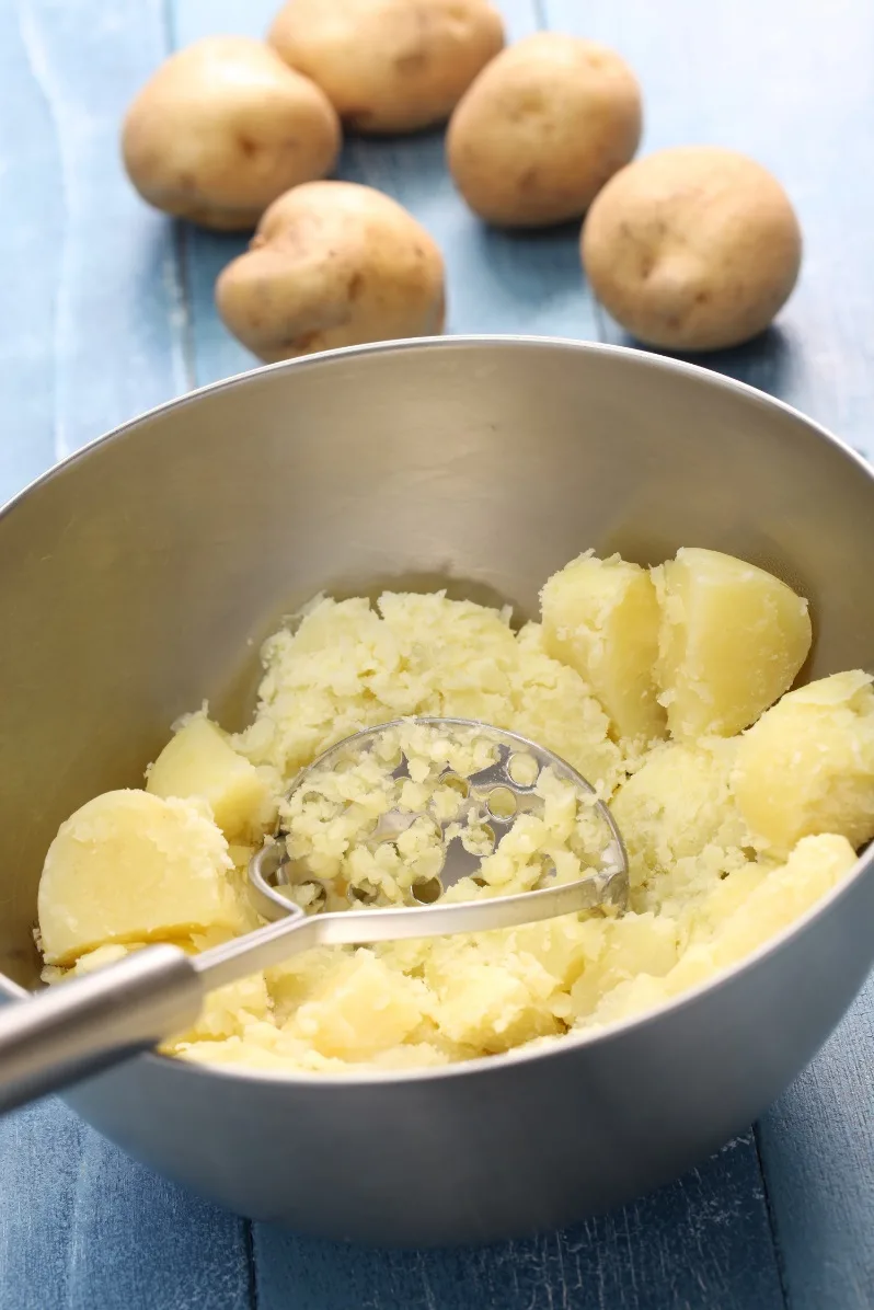 Mashing potatoes with potato masher
