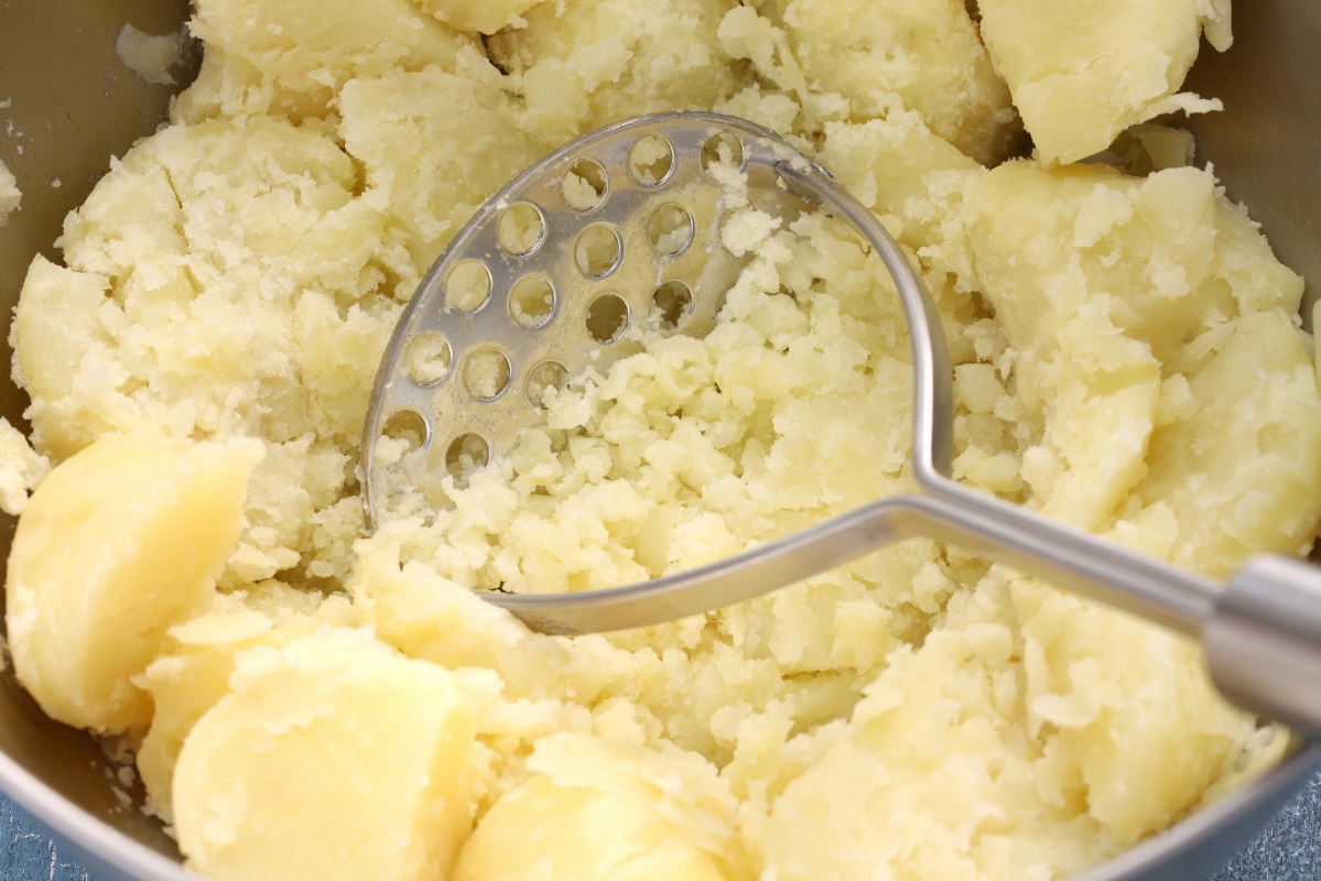 Potato Masher in bowl with potatoes
