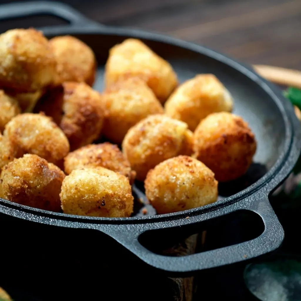 Potato croquettes in a black iron skillet