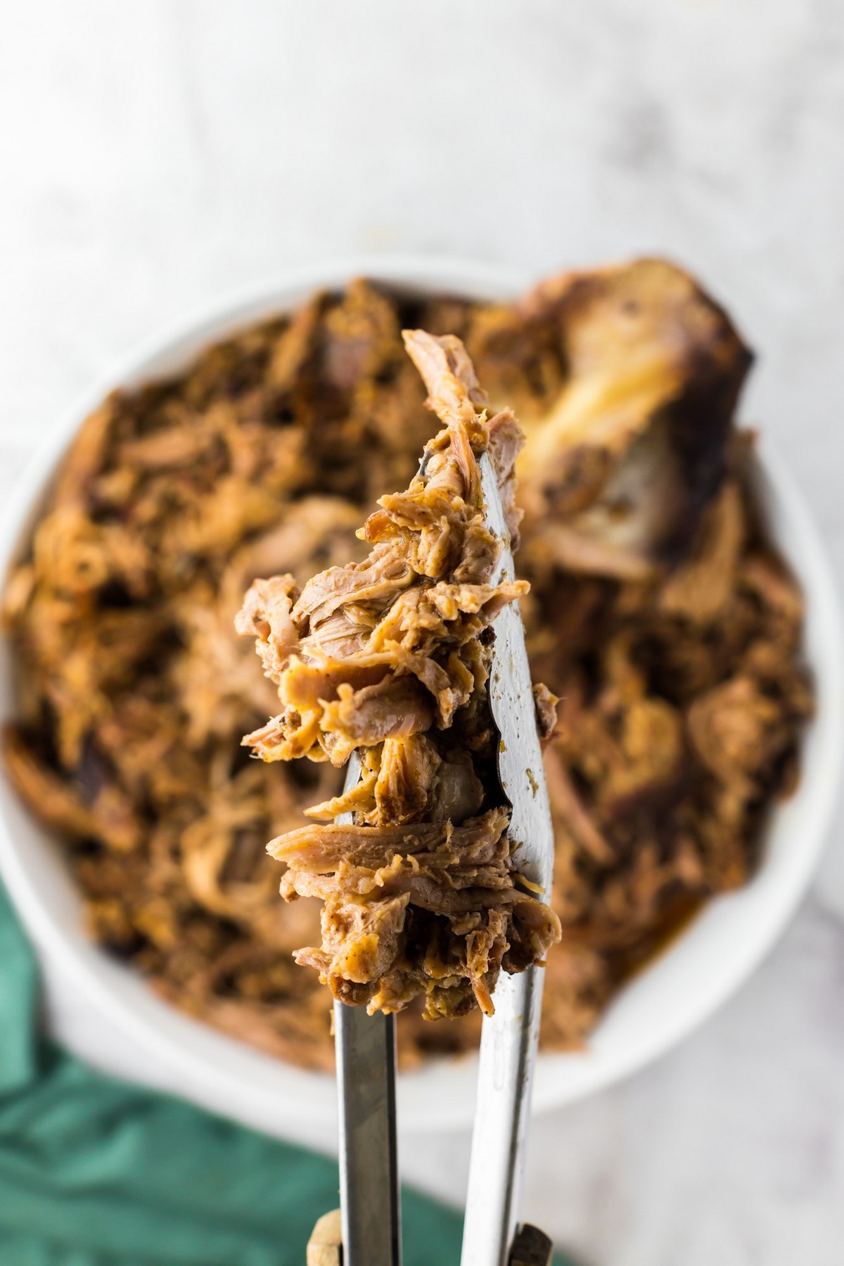 shredded pork in tongs