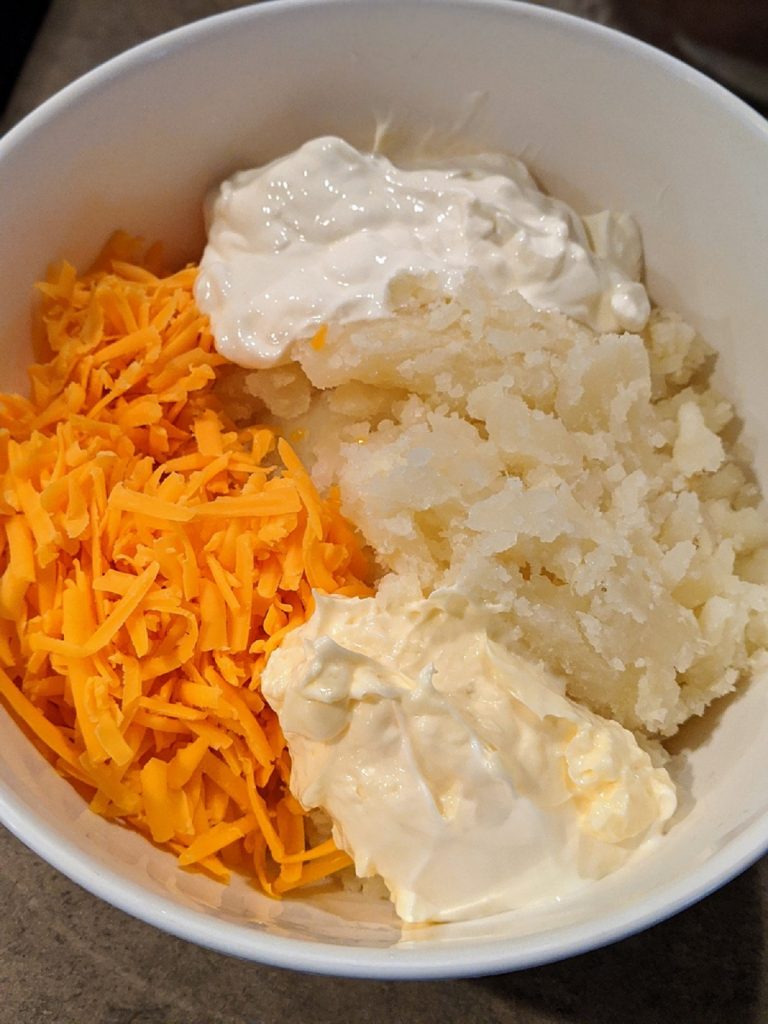 cheddar cheese, potato insides, sour cream, mayonnaise in mixing bowl