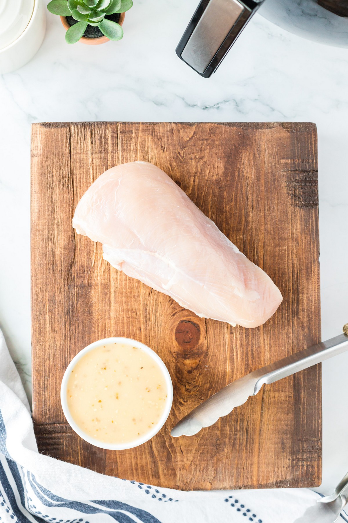 chicken breast with marinade on cutting board
