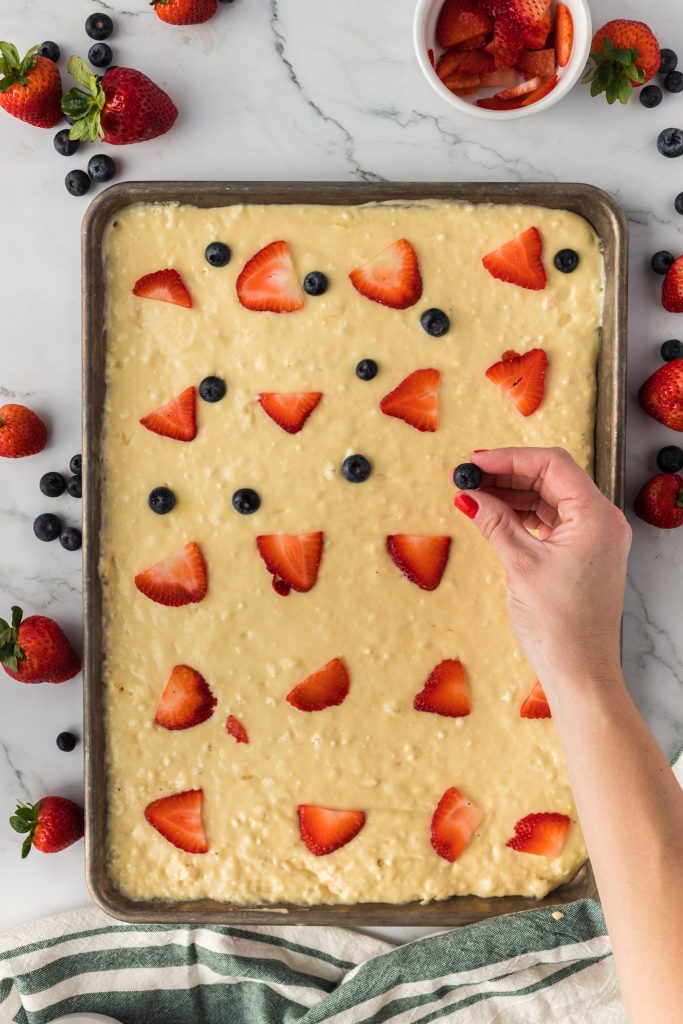 adding fruit to pancake batter on sheet pan