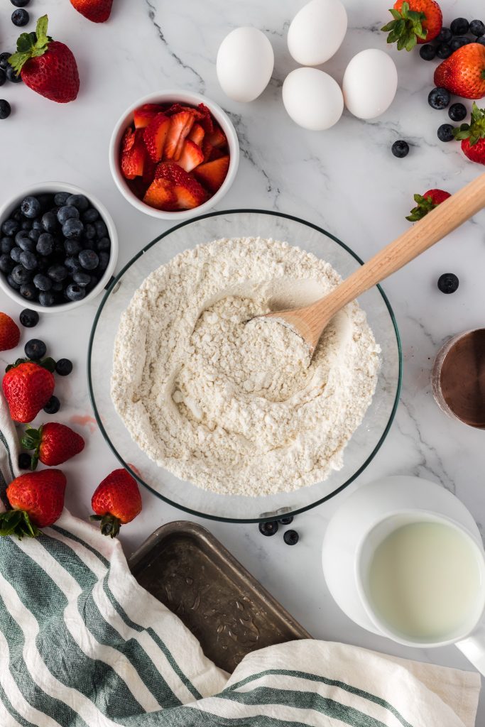bowl of flour surrounded by other ingredients to make pancake batter