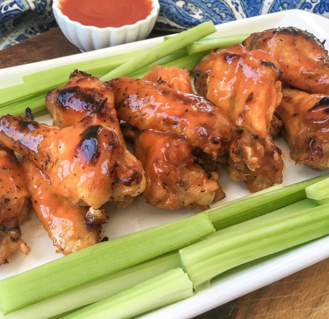 buffalo wings on a white plate with celery