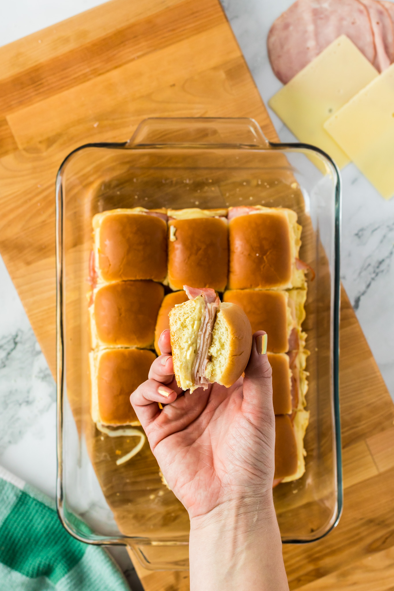 holding a slider sandwich over casserole dish