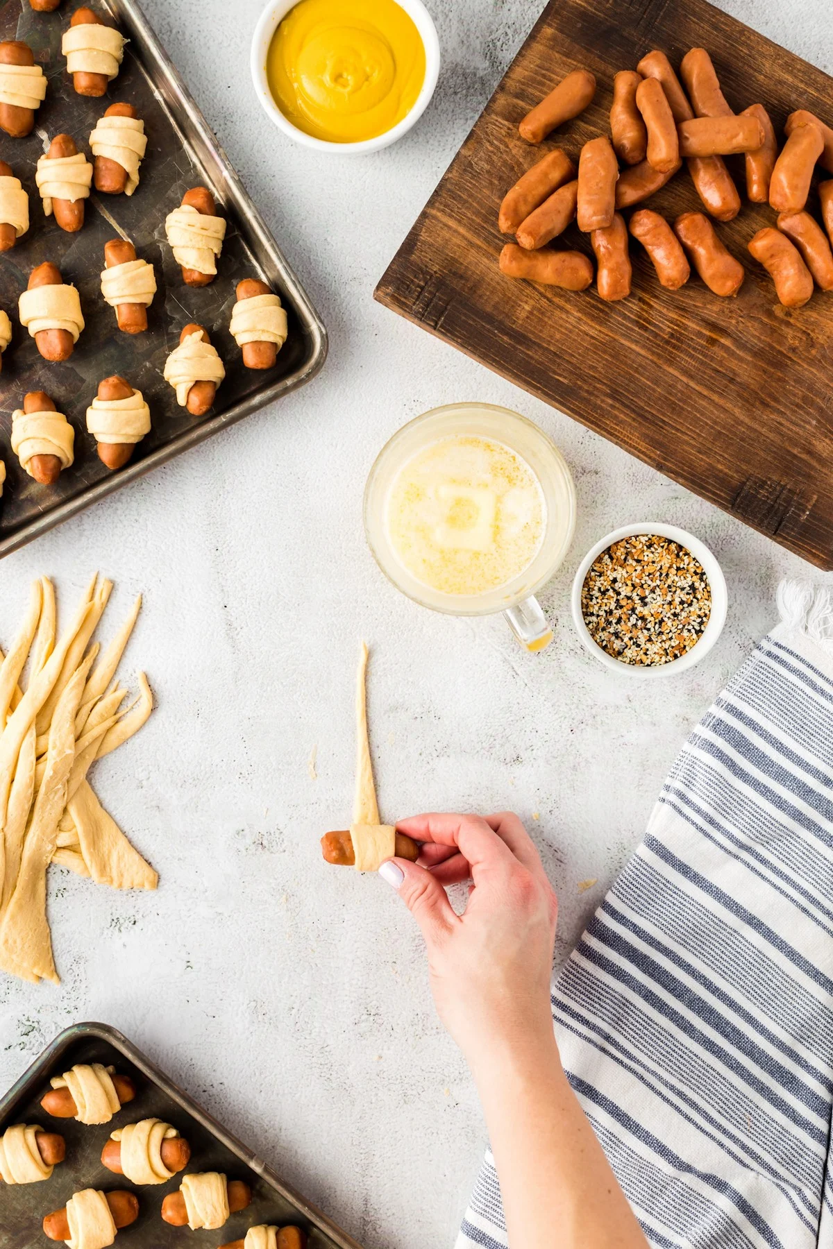 rolling mini hot dogs in crescent roll dough