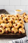 pile of pigs in a blanket on cutting board
