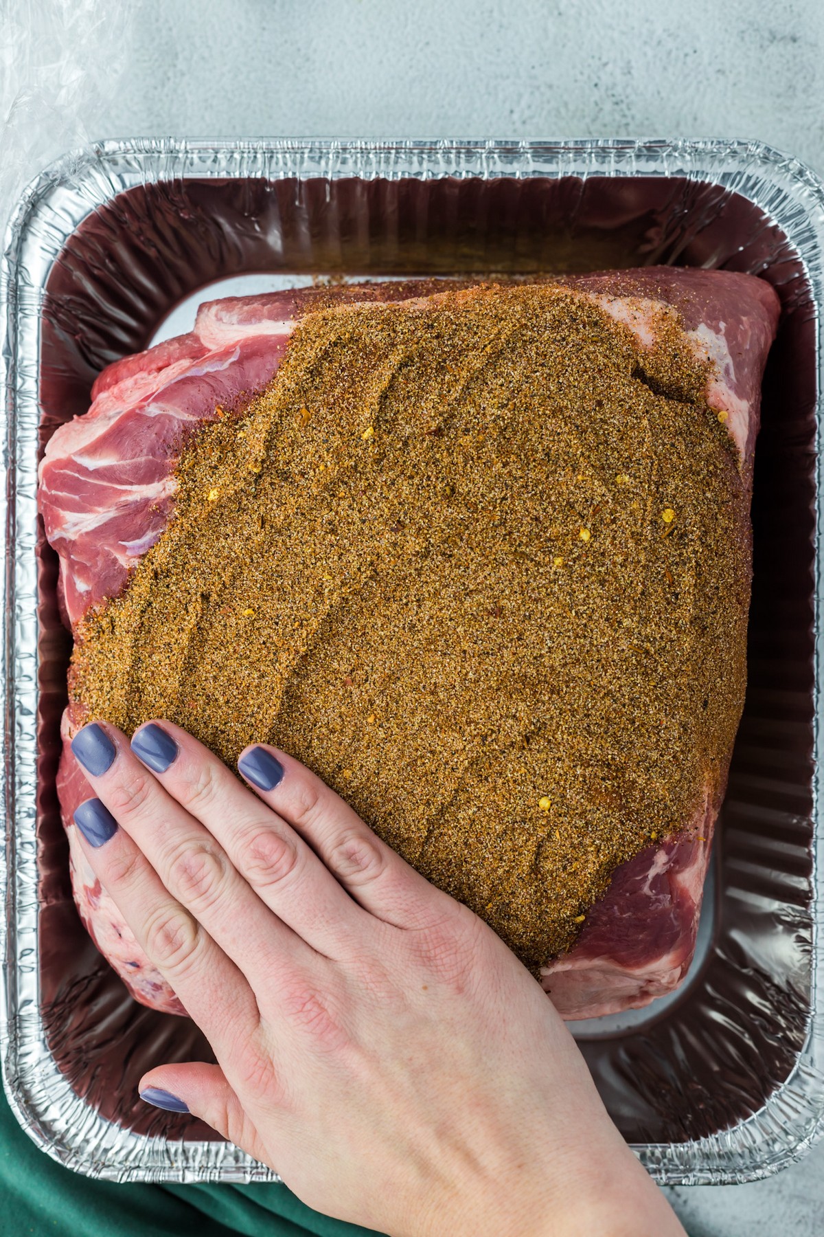 applying rub to pork shoulder