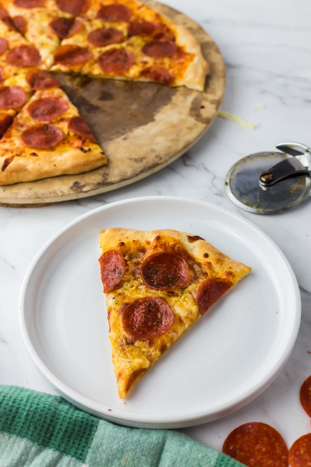 slice of pepperoni pizza on white plate