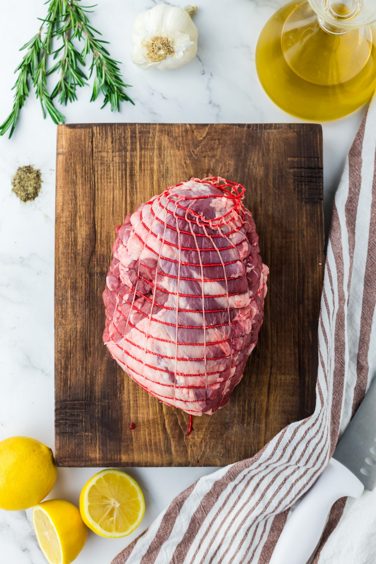 uncooked leg of lamb on cutting board