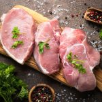 3 Pork steaks on cutting board uncooked