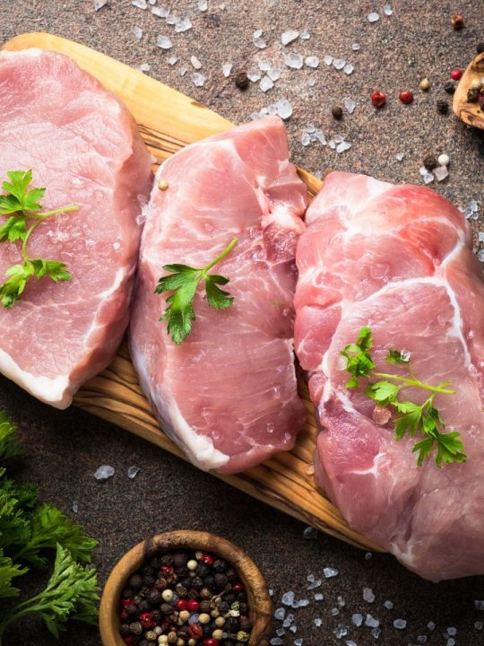 3 Pork steaks on cutting board uncooked