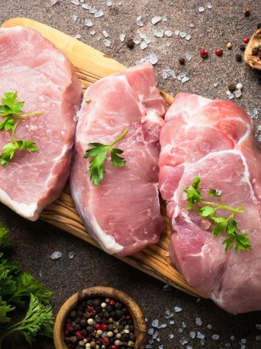 3 Pork steaks on cutting board uncooked