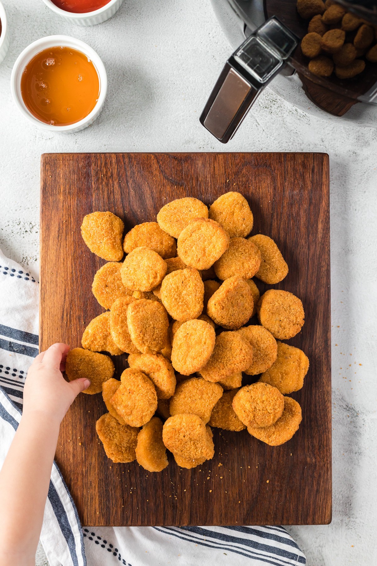 small hand grabbing chicken nugget