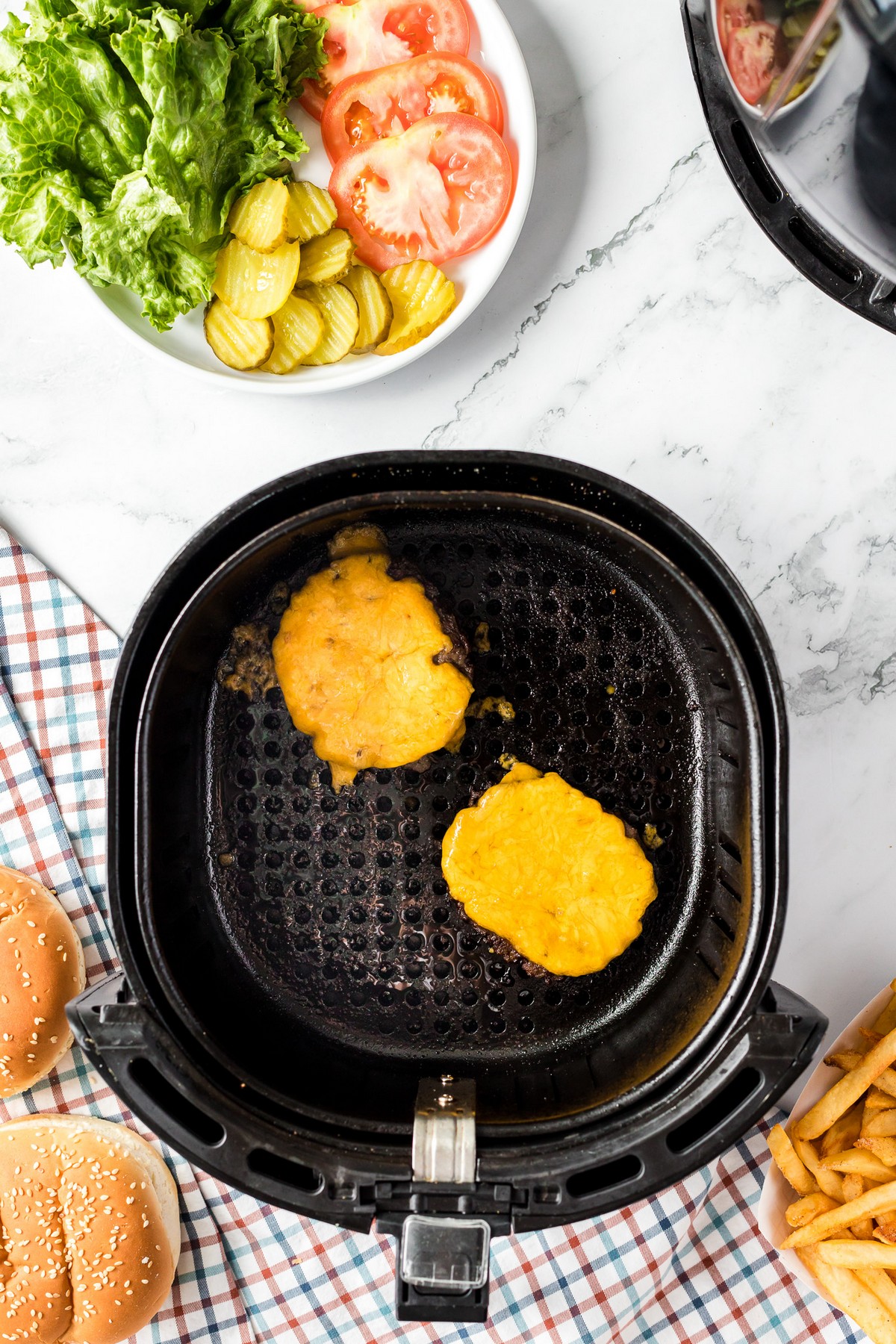 cooked hamburger patties with cheese on top in air fryer
