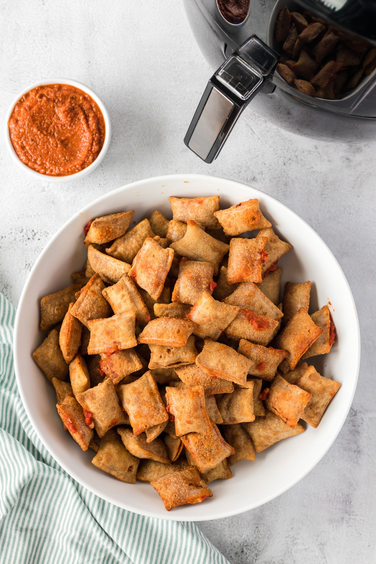 white bowl of cooked pizza rolls with sauce