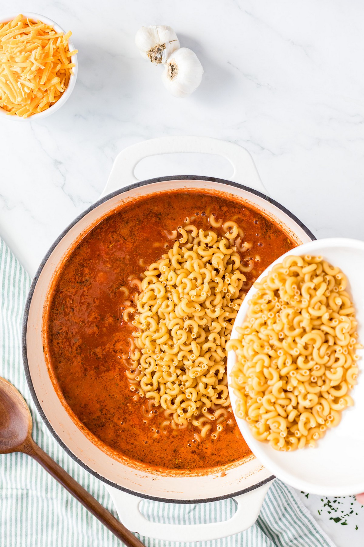 adding pasta to goulash tomato sauce