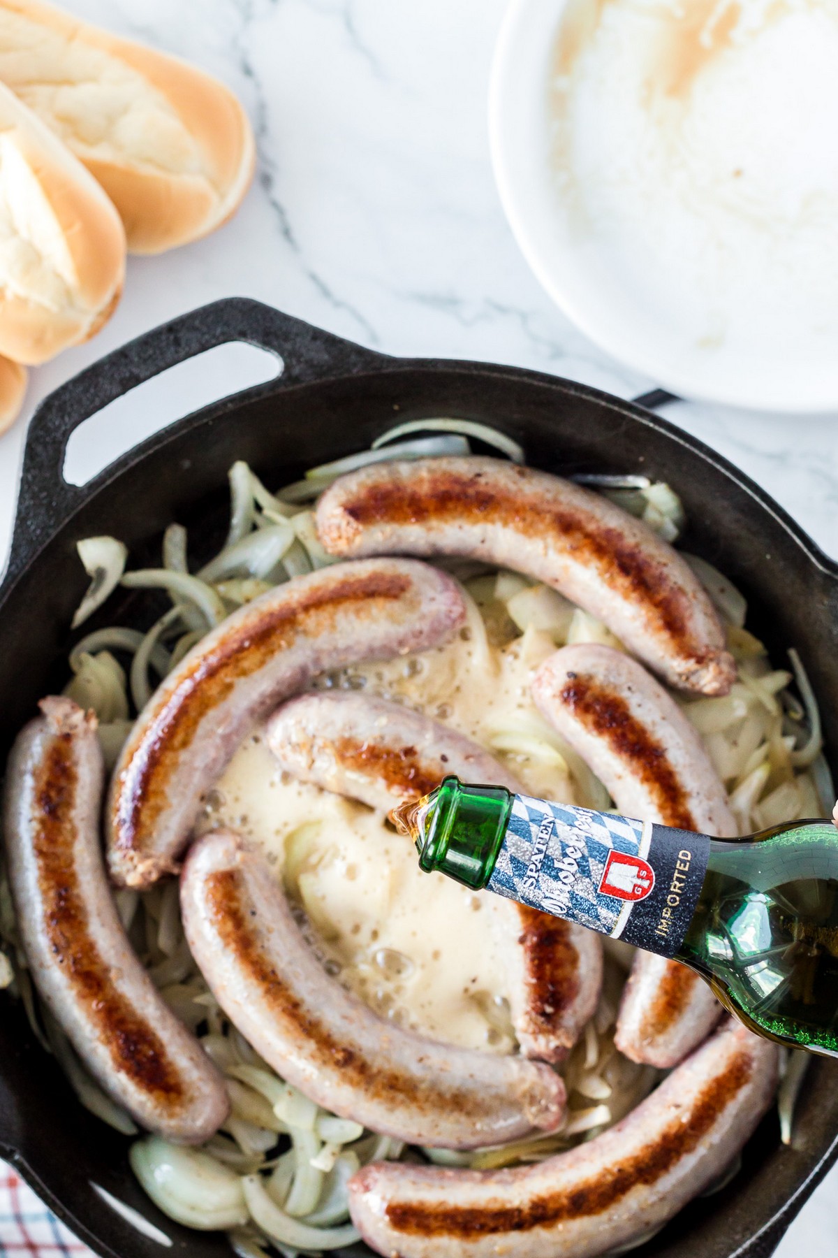 pouring beer into brats and onions