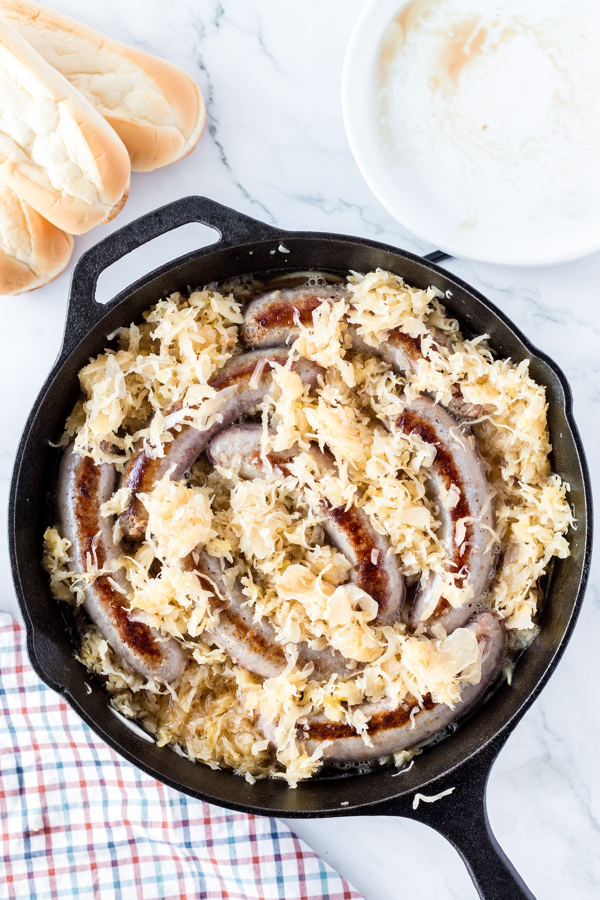 brats, onions, sauerkraut in pan