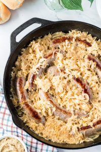 prepared beer braised bratwursts with sauerkraut and onions