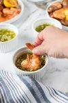 dipping shrimp into garlic butter sauce