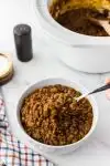 white bowl of baked beans with ground beef