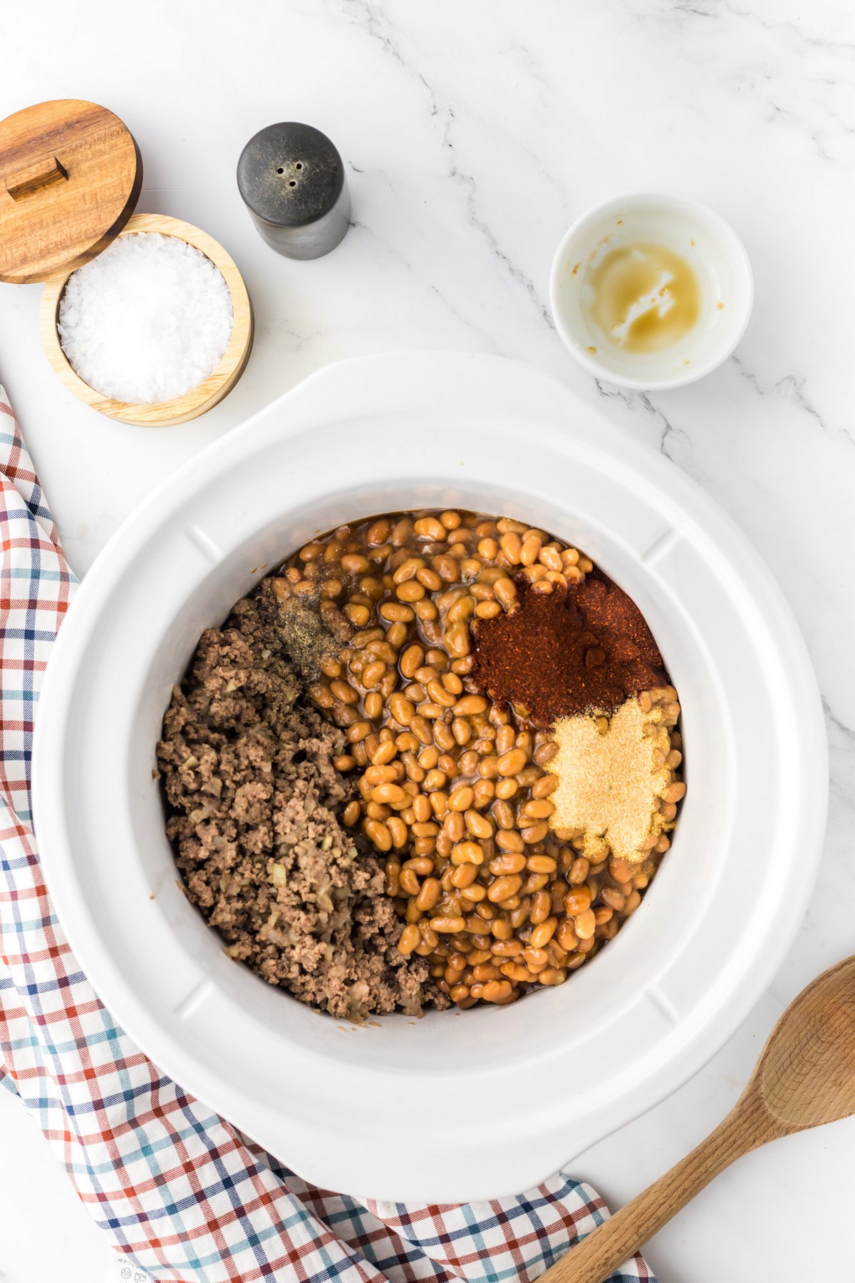 adding ingredients to a pot for baked beans