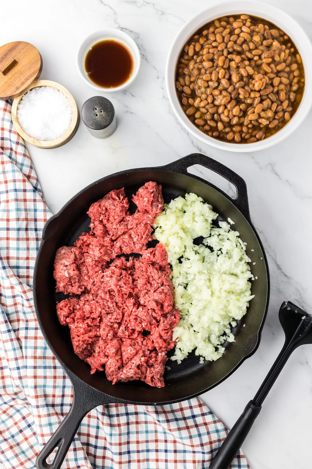 raw ground beef and onion in skillet